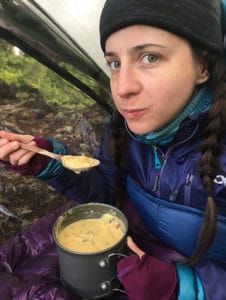 Person eating a meal out of a jetboil 