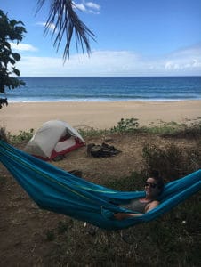 Girl sitting in hammock on beach