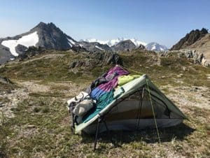 backpacking tent with sleeping bag and clothing layers on top