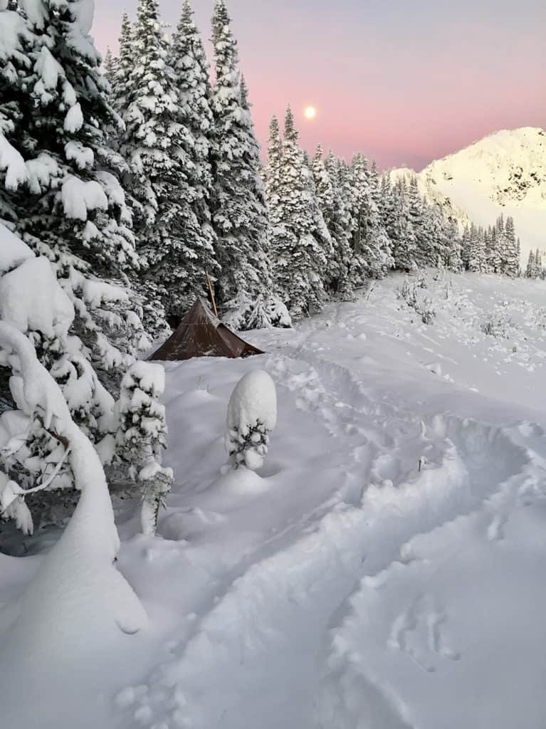 Beautiful sunrise with full moon and tent 