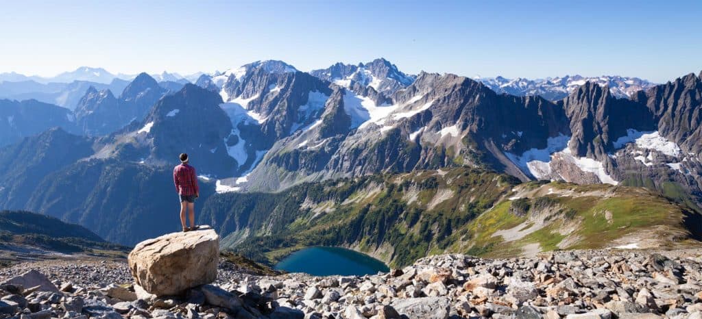 Hiker standing in front of mountain range