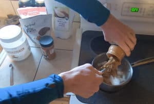 person melting nut butter and coconut oil together on stove