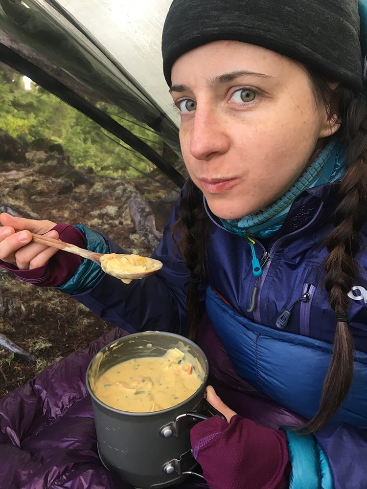 backpacker eating a diy backpacking meal