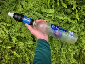 shows a smartwater bottle with a sawyer water filter connected to it