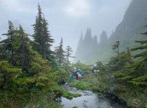 hiker filling water bottle at a stream