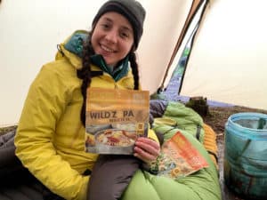 backpacker holding a paleo freeze dried backpacking meal