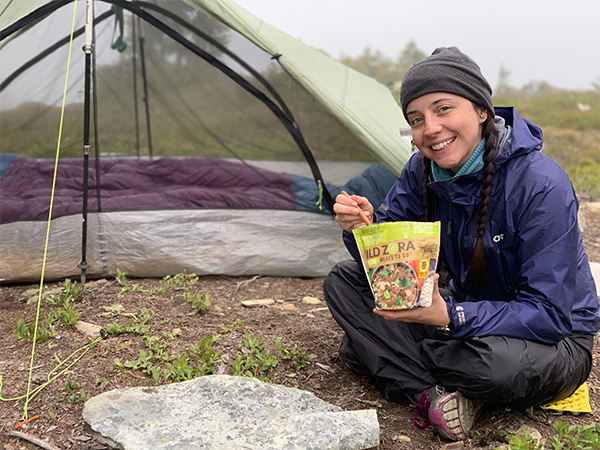 Backpacker is eating a freeze dried paleo meal