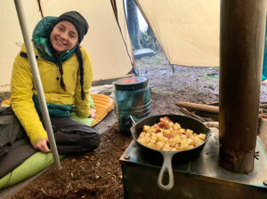 My partner staying warm thanks to the tent wood stove.