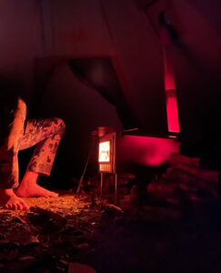 Warming my feet next to a red hot tent wood stove.